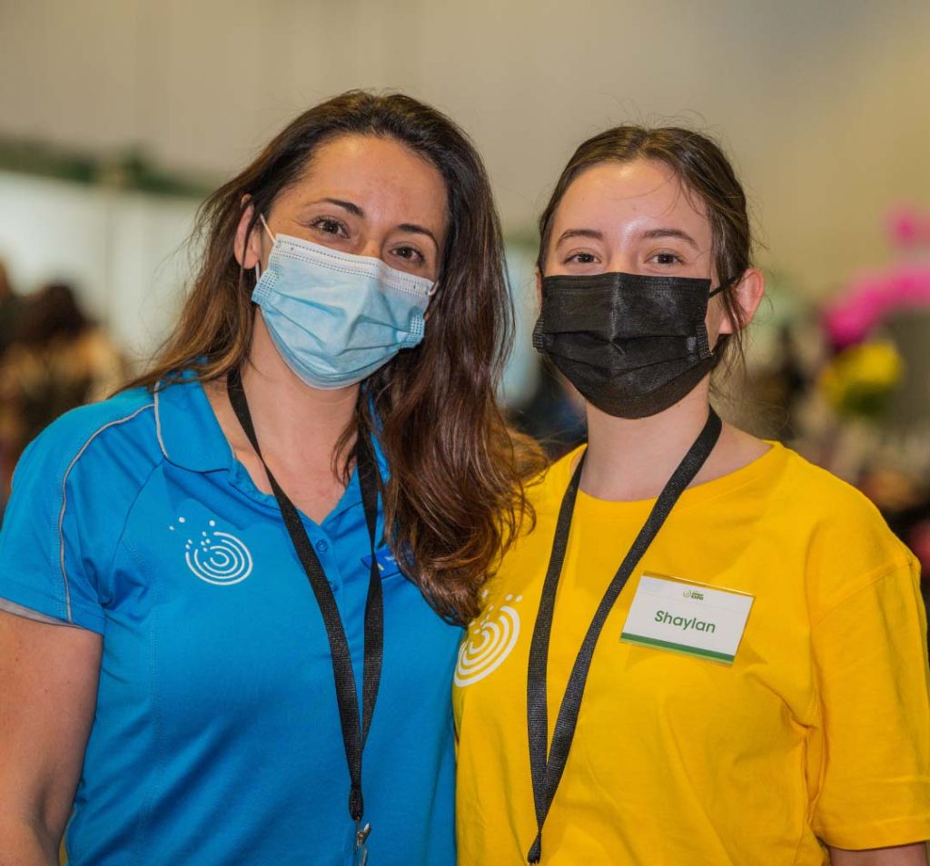 Disability Expo program - Two ladies with dark hair. Both are wearing masks