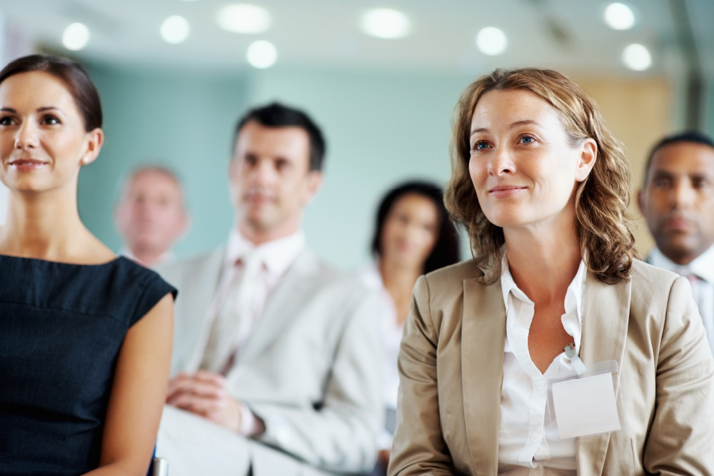 A picture of a group of business people sitting looking at a presenter who is not visible