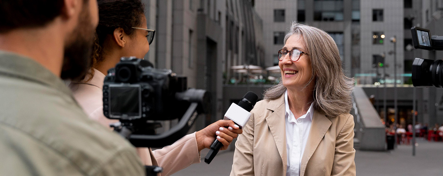 Woman being interviewed outdoors by media